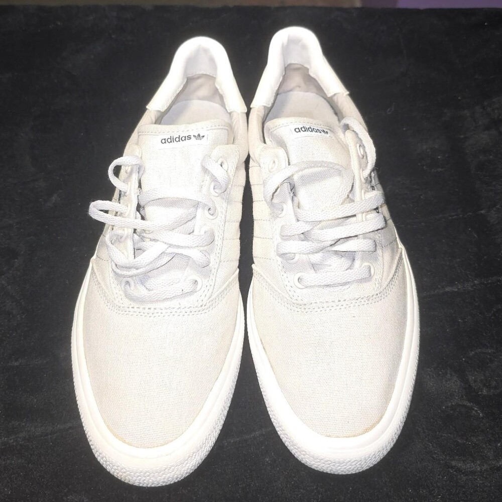 Adidas sneakers feature a minimalist, low-top design constructed from a light gr